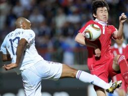 Thierry Henry de Francia, lucha contra con el defensa chino, Li Xuepeng. AFP  /