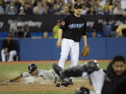 Brett Gardner de los Yanquis roba home junto al lanzador Jason Frasor de los Blue Jays de Toronto. EFE  /