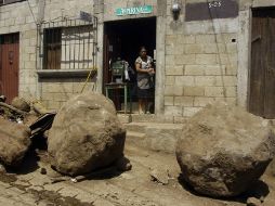 Una mujer observa la calle cubierta por rocas y escombros. REUTERS  /