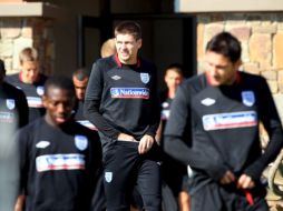 Steven Gerrard (cen) llega junto al resto de sus compañeros al campo de Rustembugo. EFE  /