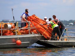 Trabajadores recogen las barreras de contención que se utilizan para contener el petróleo, en Mississippi. AP  /