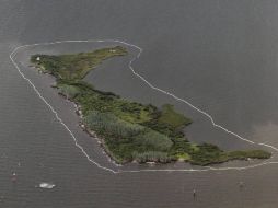 Isla rodeada por una manguera que absorbe el crudo. Los intentos por limpiar el agua continúan. EFE  /