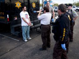Un manifestante es detenido por bloquear la entrada del centro temporal de procesamiento para los ilegales. EFE  /