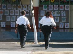 Guardias de seguridad privada vigilan una escuela. La demanda de servicios de seguridad privada subió 11% de enero a julio. ARCHIVO  /