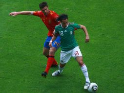 Andrés Guardado disputa el balón contra Xavi Alonso. MEXSPORT  /