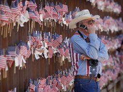 Los manifestantes pegaron cientos de banderas estadounidenses a los postes del muro, en apoyo a la ley antiinmigrante de Arizona. AP  /
