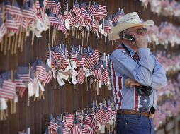 Un miembro del Partido del Té habla por teléfono a un lado del muro fronterizo que divide Nogales y Hereford. AP  /