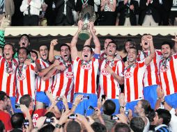 Toño López, capitán del Atlético, levanta la Supercopa junto a todos sus compañeros. EFE  /