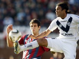 Fabián Cubero (derecha) disputa balón en partido ante San Lorenzo. EFE  /
