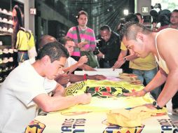 Óscar Rojas firma la camiseta de un aficionado durante un evento de la firma que viste al América. MEXSPORT  /
