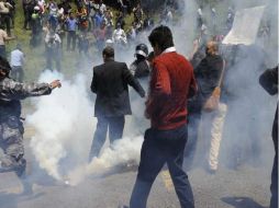 Rafael Correa es evacuado en una camilla desde el cuartel de Regimiento Quito en medio de una nube de gas lacrimógeno. AFP  /