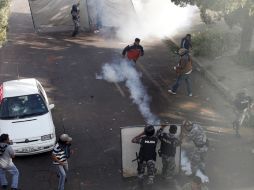 Policías que protestan contra el presidente Correa se enfrentan a un grupo de seguidores del mandatario. REUTERS  /