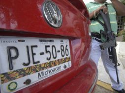 Un agente de la Procuraduría General del Estado de Guerrero presta guardia a uno de los vehículos. EFE  /