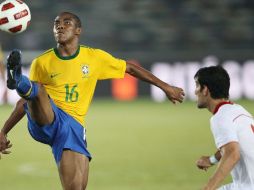 El brasileño Elías izq controla el balón ante el iraní Ehsan Hajy durante un partido amistoso entre Brasil e Irán. EFE  /