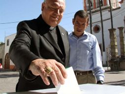 El cardenal Juan Sandoval Íñiguez, acompañado del alcalde Miguel Castro, emitió su voto ayer. M. FREYRIA  /