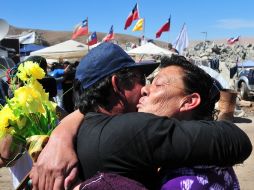 En la boca de la mina, los familiares recibieron con llanto y alegría la noticia de la finalización del ducto de rescate. AFP  /