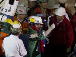 Luis Urzúa (centro) tras salir hoy de la mina San José. AFP  /