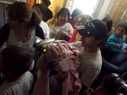 El minero Ariel Ticona sostiene a su hija Esperanza, quien nació mientras él estaba atrapado en la mina San José. EFE  /