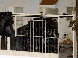 Al llegar al sitio, autoridades colocaron plásticos negros para evitar la difusión de imágenes del crimen. EFE  /