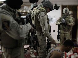 Un hombre es interrogado por un comando de operaciones especiales iraquíes, mientras que un camarógrafo graba la escena. AFP  /