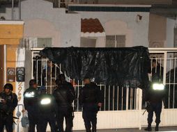Policías federales resguardan el domicilio en el que fueran asesinados 14 jóvenes. AFP  /