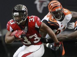 Los Halcones de Atlanta Michael Turner (iz) son perseguidos por el defensor de Cincinnati Robert Geathers (der). AP  /