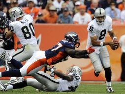 El mariscal de campo de los  Raiders Jason Campbell, (der) se escapa de  Mario Haggan (iz) de Bronco. AP  /