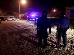 Policías federales vigilan las investigaciones que realizan los peritos forenses en el lugar donde siete jóvenes fueron asesinados. EFE  /