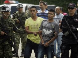 Policías escoltan a dos presuntos miembros de las FARC, detenidos durante el enfrentamiento. AP  /