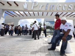 Un empleado herido descansa en una protesta de compañeros locales fuera del hotel. AP  /