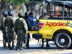 Militares custodian a los policías municipales detenidos tras una operación lanzada por personal de la Marina, en Apodaca. EFE  /