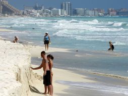 La cita será inaugurada el próximo lunes por el Presidente, Felipe Calderón. Los turistas se divierten en las playas de Cancún. AP  /