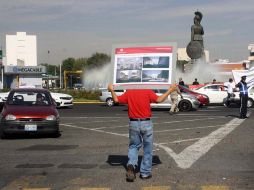 Trabajador del Ayuntamiento tapatío con un cartel promocional del paso a desnivel en La Minerva. ARCHIVO  /