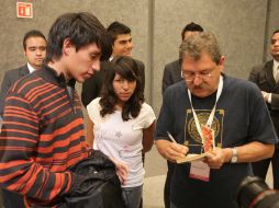 Paco Ignacio Taibo II firma un libro suyo a un joven antes de la charla que encabezó junto con su hermano Benito Taibo. A. CAMACHO  /