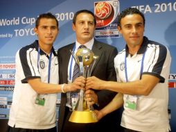 El entrenador del Pachuca Pablo Marini (centro) posa con a sus jugadores Paul Aguilar (izq.) y Leobardo Lopez con el trofeo. AFP  /