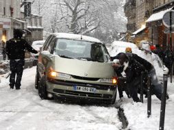 Personas tratan de liberar un auto atorado tras la intensa nevada. REUTERS  /
