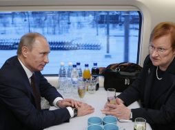 El premier ruso Vladimir Putin y la presidenta de Finlandia, Tarja Halonen, conversan en el flamante tren. REUTERS  /