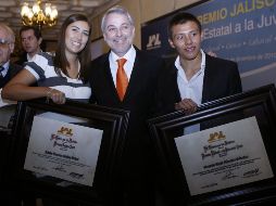 La arquera Linda Ochoa y el clavadista Germán Sánchez posan con sus reconocimientos junto al gobernador de Jalisco. M. FREYRÍA  /