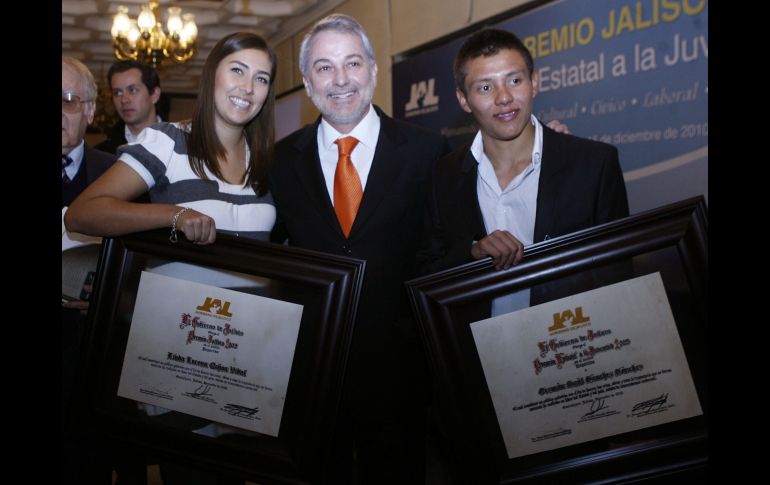 La arquera Linda Ochoa y el clavadista Germán Sánchez posan con sus reconocimientos junto al gobernador de Jalisco. M. FREYRÍA  /