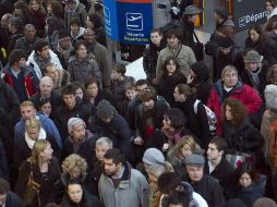 Paseantes se reúnen frente a paneles informativos en el aeropuerto de Francia. AP  /