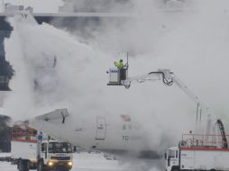 Miembros de los servicios de mantenimiento de aeropuerto  descongelan un avión de Turkish Airlines. EFE  /