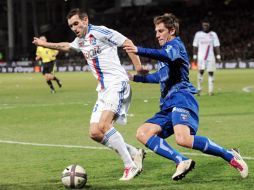 El defensa Reveillere (izq) seguirá jugando para el Olympique de Lyon. AFP  /