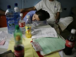 Una enfermera duerme sobre una mesa para reponerse de la agotadora jornada en el área de emergencias. AP  /