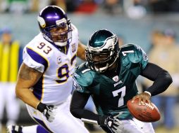 Michael Vick huye de la presión del defensivo de Minnesota durante el partido de martes por la noche. AP  /
