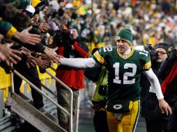 El mariscal de campo de Green Bay, Aaron Rodgers, celebra con los aficionados el pase a postemporada tras ganar a Chicago. AP  /