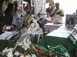 Dolientes se reúnen al rededor de los ataudes del edil fallecido y su hijo. REUTERS  /