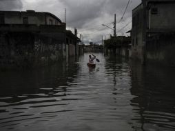 Un vecino cruza por un vecindario en San Pablo. Las inundaciones son el primer gran desafío para el Gobierno de Dilma Roussef. AFP  /