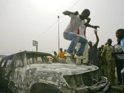 Un marfileño salta sobre un vehículo de las Naciones Unidas (ONU). EFE  /