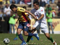 El defensa mexicano de Morelia, Enrique Pérez (i), disputa el balón con Michel Vázquez (d) de Chivas. EFE  /