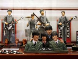 Muñecos que representan a los músicos, tazas y platos con sus imágenes pueden apreciarse en el recinto. AP  /